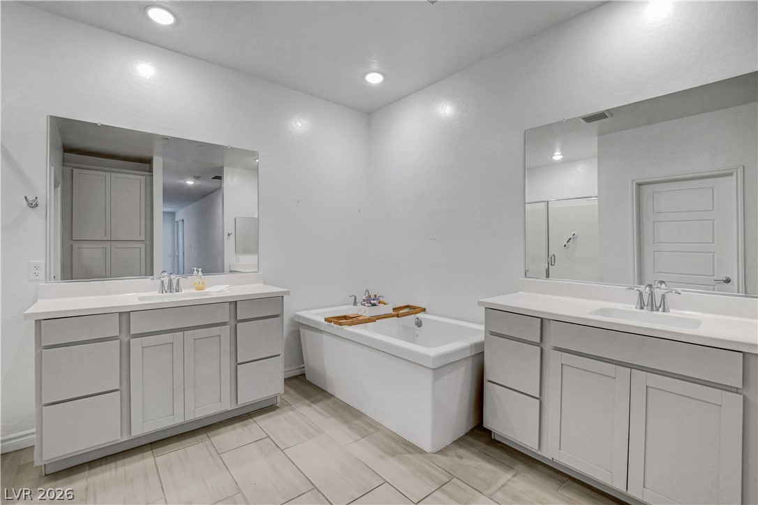 2555 Hampton Road, Unit 2207 Henderson, NV 89052 - Photo 30 of 74 A naturally illuminated primary bathroom offers a large soaking tub and dual vanities with expansive mirrors.