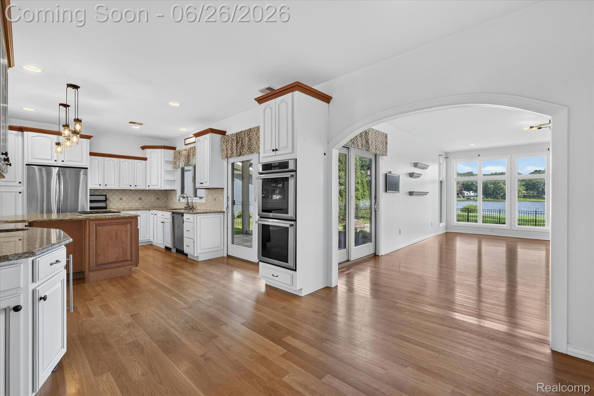 3478 Lexington Road Waterford, MI 48328 - Photo 6 of 52 Kitchen featuring wood-finish flooring, white cabinetry with wood trim, stainless steel appliances, and granite countertops