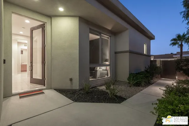 a living room with stainless steel appliances kitchen island granite countertop a couch and a flat screen tv