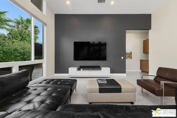 a living room with furniture and floor to ceiling windows