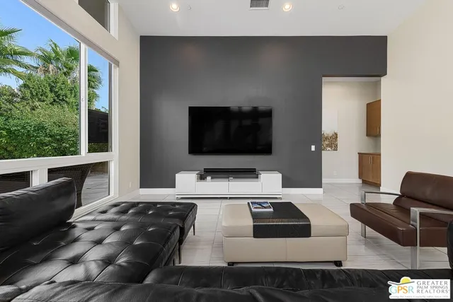 a living room with furniture and floor to ceiling windows
