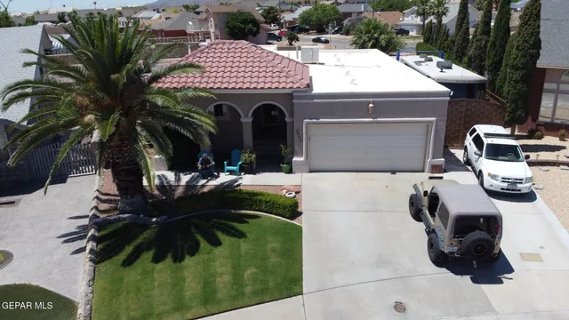 a view of a patio with table and chairs under an umbrella with a garden