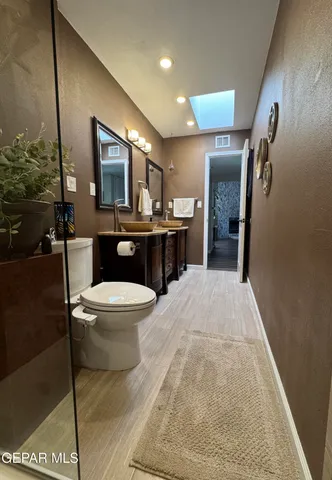 a spacious bathroom with a granite countertop toilet a sink and a large mirror