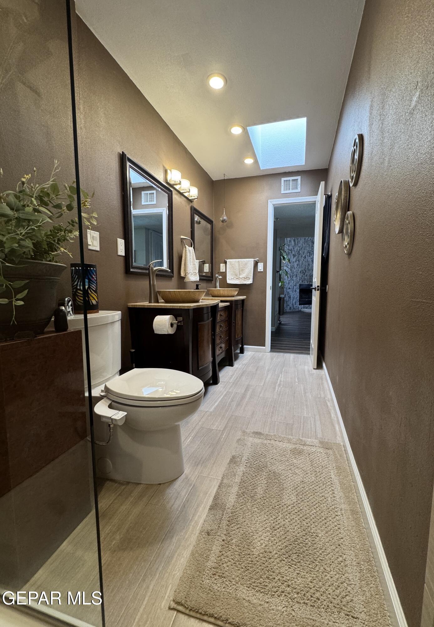 4621 Esparza Lane El Paso, TX 79934 - Photo 19 of 24 a spacious bathroom with a granite countertop toilet a sink and a large mirror