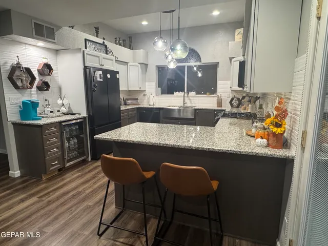a kitchen with granite countertop a sink cabinets and stainless steel appliances