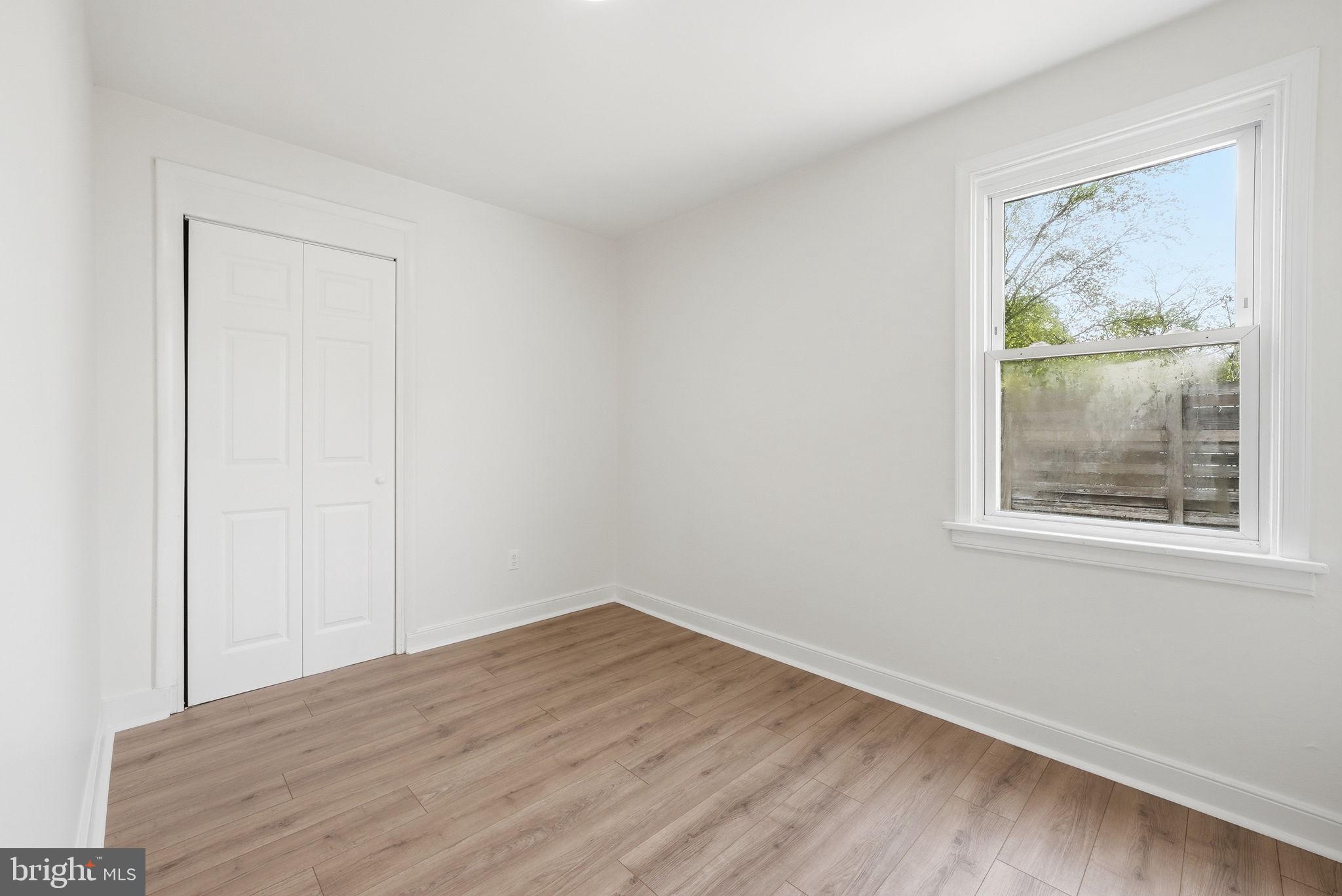 12304 Livingston Street Silver Spring, MD 20902 - Photo 14 of 20 a view of an empty room with wooden floor and a window
