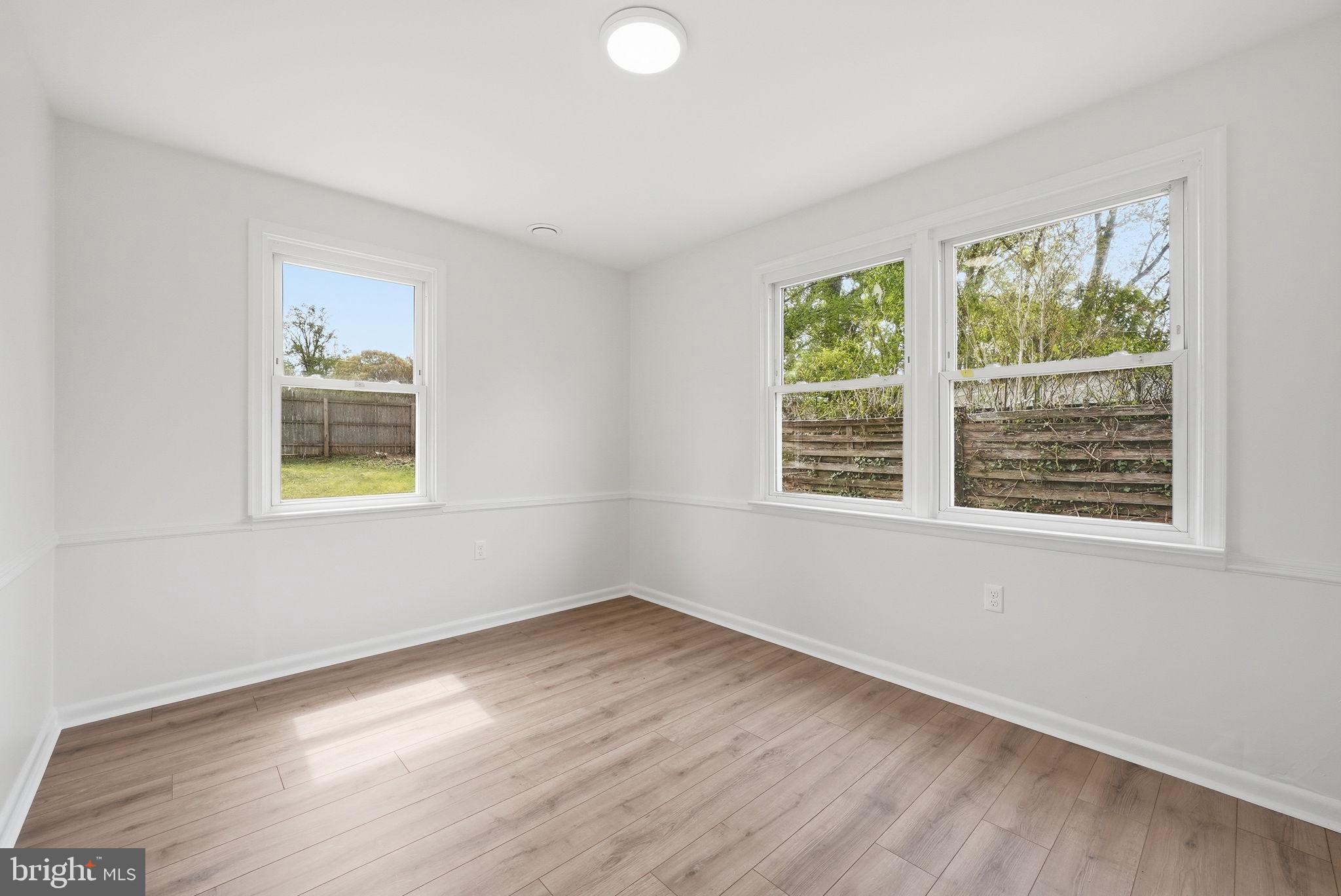 12304 Livingston Street Silver Spring, MD 20902 - Photo 15 of 20 a view of an empty room with wooden floor and a window