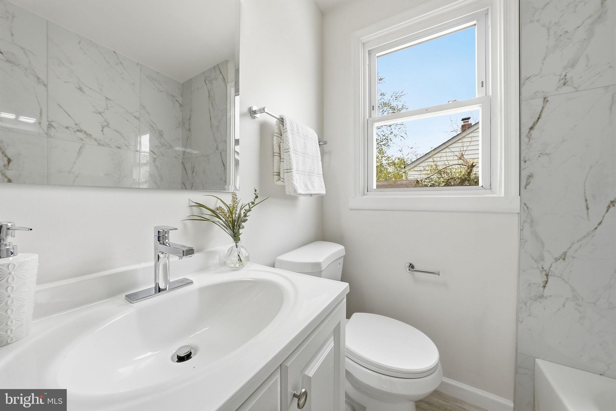 12304 Livingston Street Silver Spring, MD 20902 - Photo 18 of 20 a bathroom with a sink a toilet and a mirror