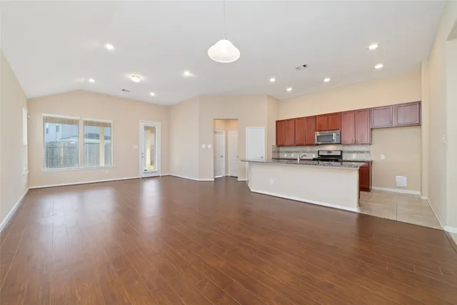 a view of kitchen with refrigerator stove and wooden cabinets