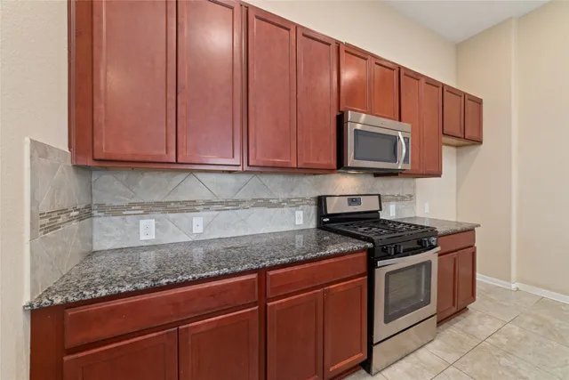 a kitchen with granite countertop a stove and a sink