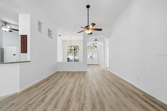 a view of a room with wooden floor and a ceiling fan