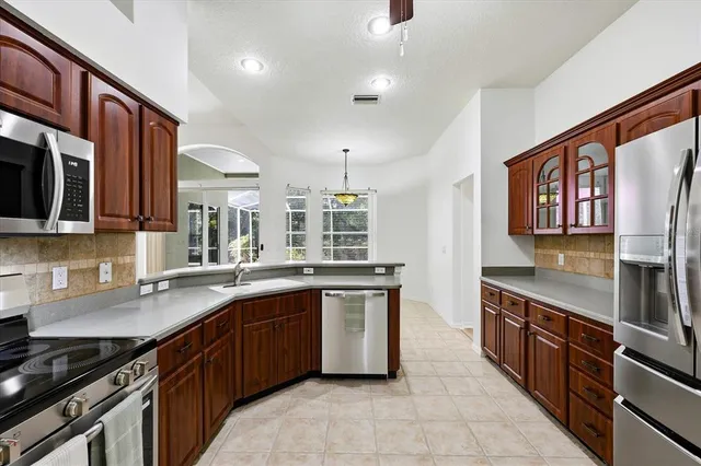 a kitchen with stainless steel appliances granite countertop a stove sink and cabinets
