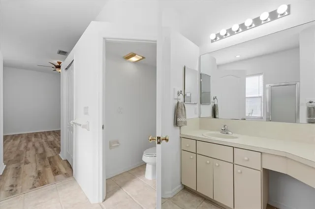 a bathroom with a double vanity sink mirror and toilet