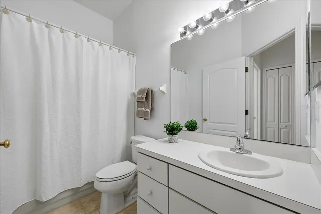 a bathroom with a sink a toilet and shower curtain