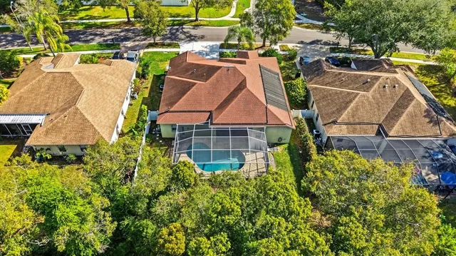 a aerial view of a house with swimming pool and large trees
