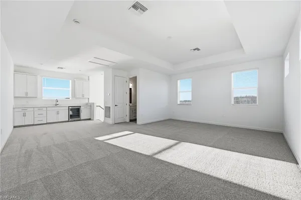 a view of an empty room with a kitchen