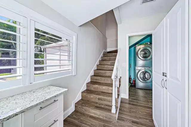 a bedroom with a bed a large window and a chandelier
