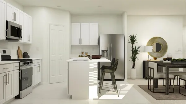 a kitchen with a sink a stove and white cabinets