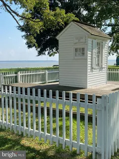 a view of a house with a small yard and wooden fence