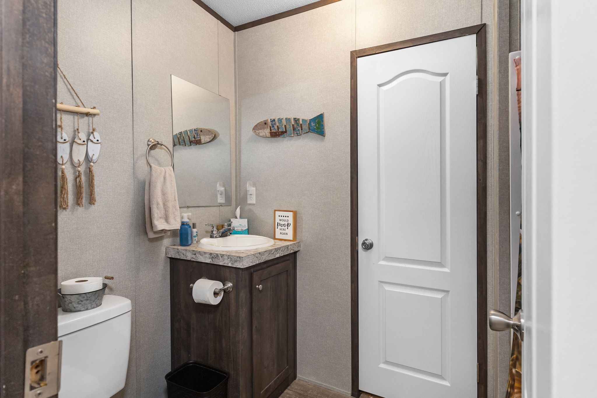 275 Bryan Street Zavalla, TX 75980 - Photo 14 of 24 a bathroom with a granite countertop sink a toilet a mirror and vanity