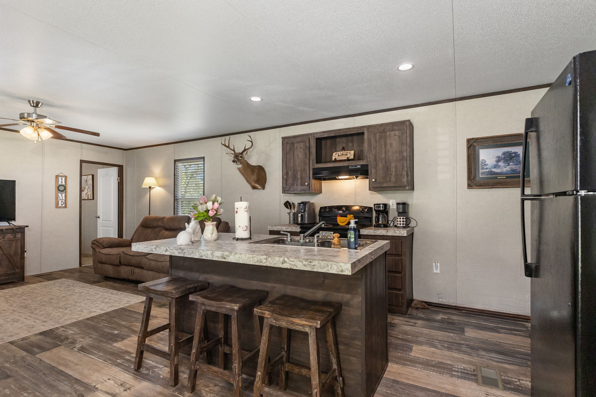 275 Bryan Street Zavalla, TX 75980 - Photo 9 of 24 a kitchen with a table chairs refrigerator and microwave