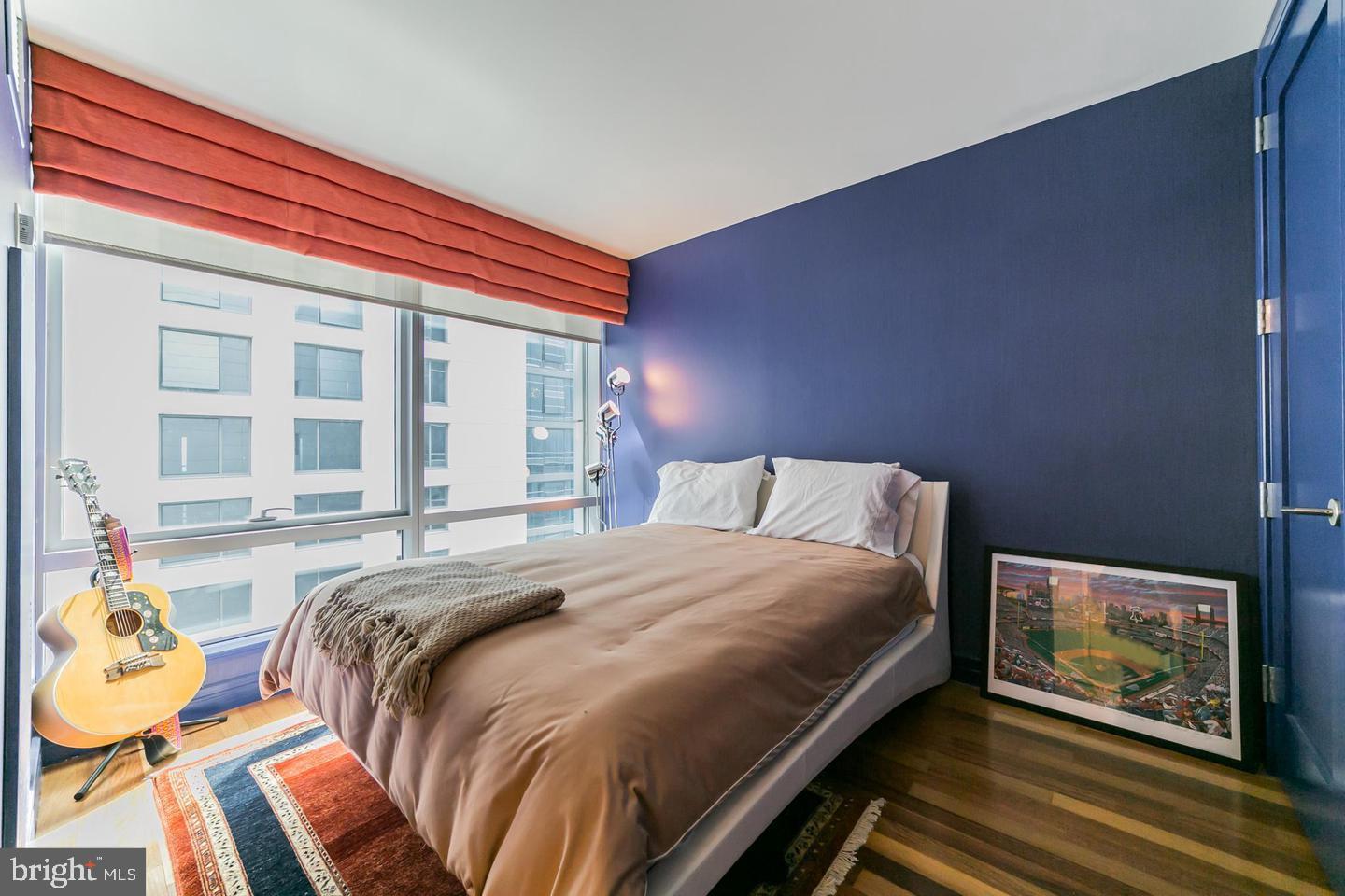 1414 South Penn Square, Unit 45A Philadelphia, PA 19102 - Photo 23 of 23 a bedroom with a bed and wooden floor