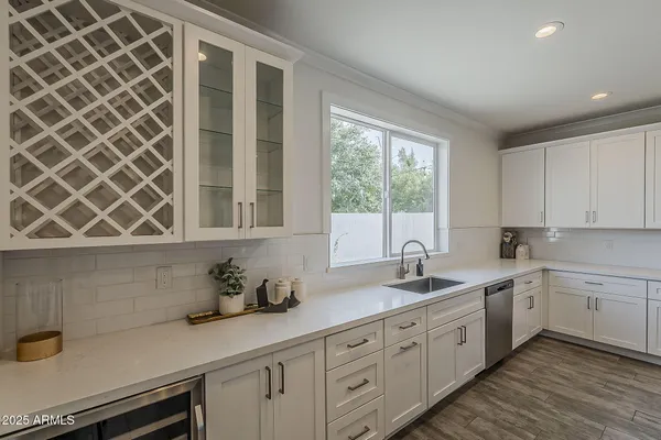 a kitchen with white cabinets and sink