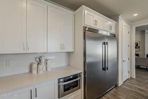 a backyard of a house with plants and trees with wooden fence