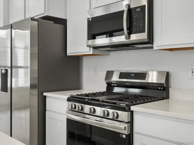 a kitchen with stainless steel appliances granite countertop a stove and a microwave