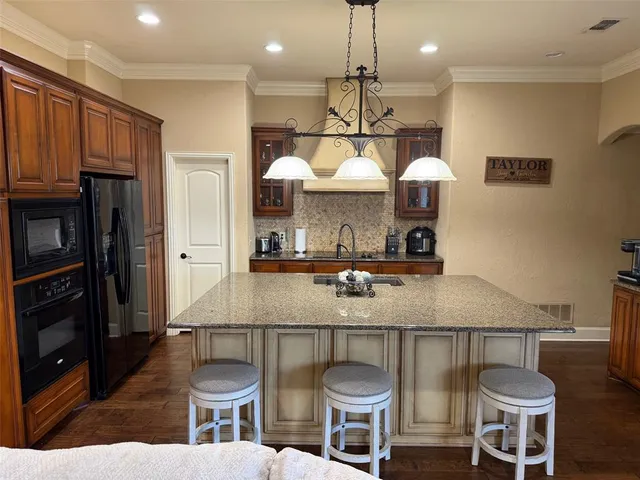 a kitchen with stainless steel appliances granite countertop a sink a stove and a refrigerator