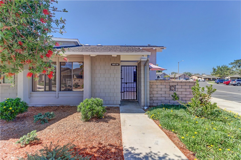 8565 Larkhall Circle, Unit 802C Huntington Beach, CA 92646 - Photo 1 of 42 a view of a house with a small yard and plants