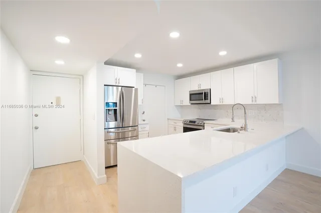 a kitchen with stainless steel appliances a refrigerator sink and microwave