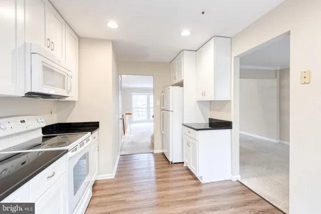 a kitchen with cabinets and wooden floor