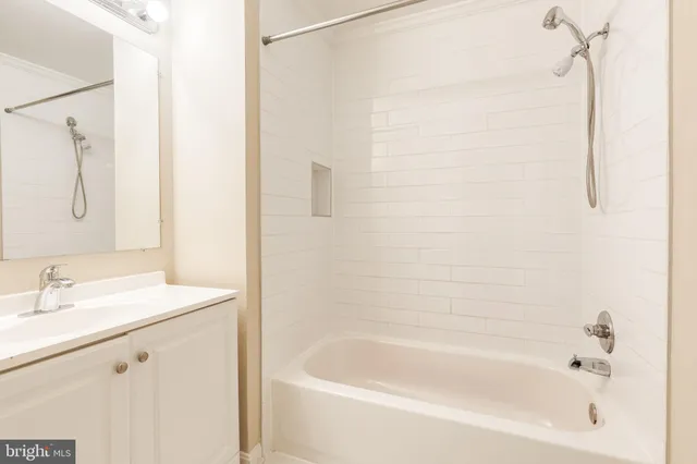 a white bath tub sitting next to a white sink and vanity
