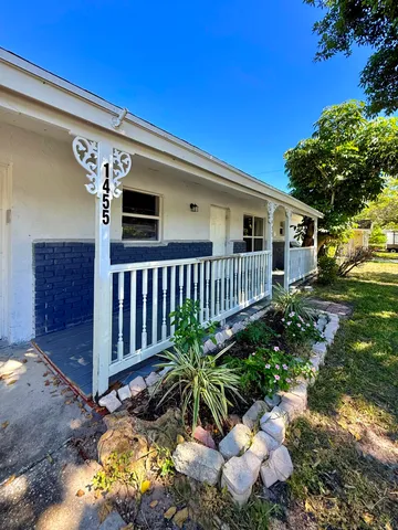 a kitchen with stainless steel appliances granite countertop a refrigerator a stove a sink and white cabinets with wooden floor