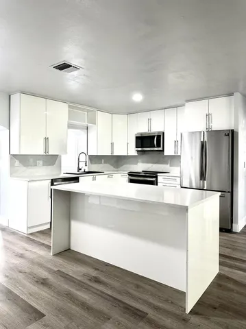 a utility room with wooden floor washer and dryer