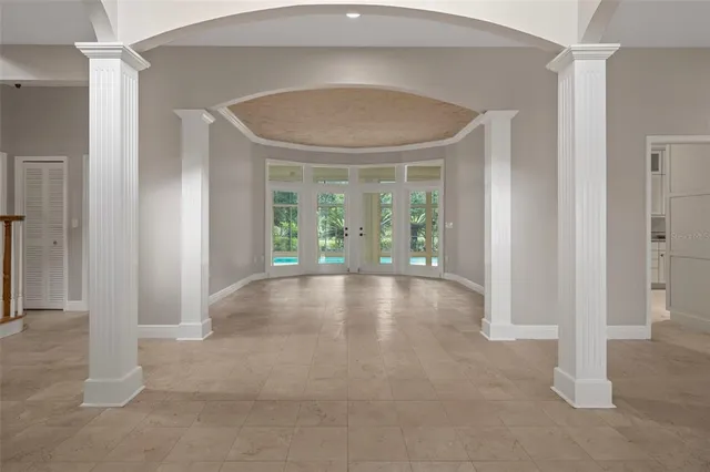 a view of an empty room with glass door and windows
