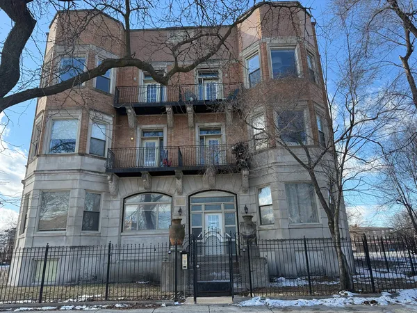 a front view of a house with iron fence