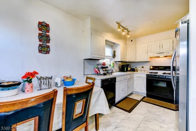 a kitchen with stainless steel appliances kitchen island granite countertop a sink dishwasher stove and refrigerator with wooden cabinets