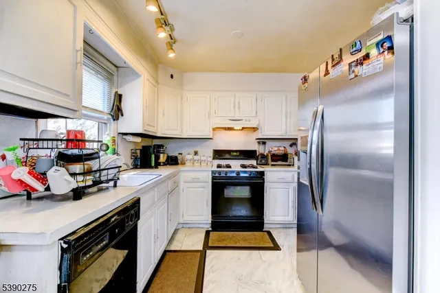 a kitchen with stainless steel appliances and a refrigerator