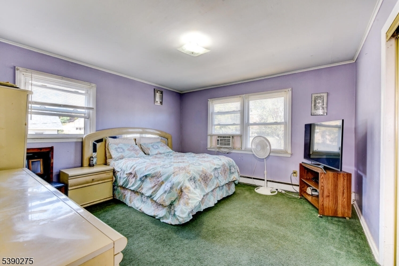 910 Wootton Street Boonton, NJ 07005 - Photo 9 of 21 a spacious bedroom with a bed and a flat tv screen on dresser