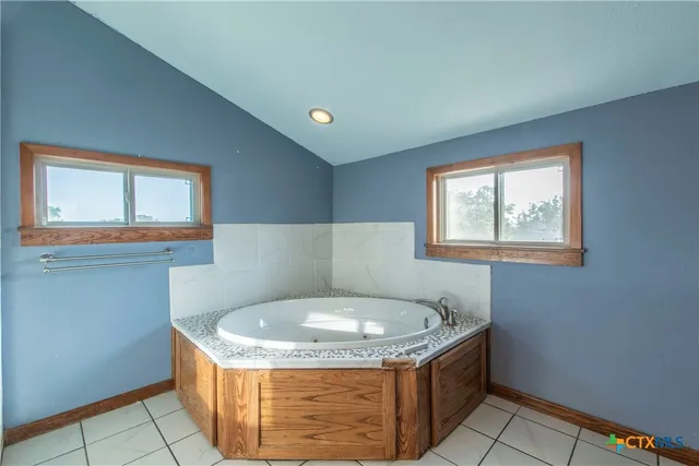 a bathroom with a granite countertop bathtub and sink