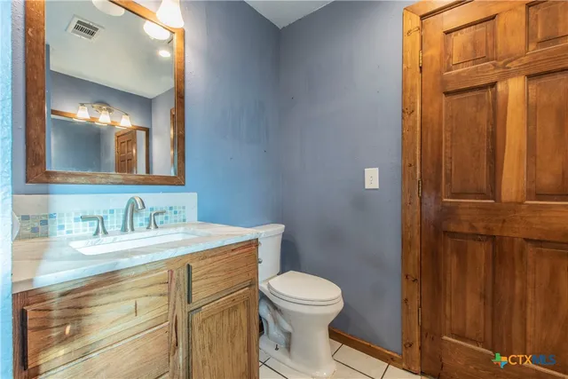 a bathroom with a granite countertop sink mirror vanity and toilet