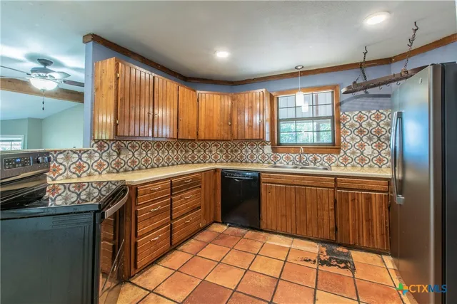 a kitchen with granite countertop a sink stove and cabinets