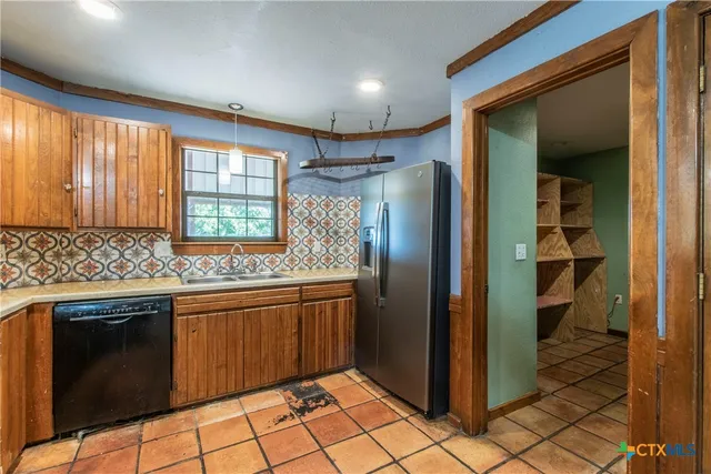 a kitchen with stainless steel appliances granite countertop a refrigerator and a sink