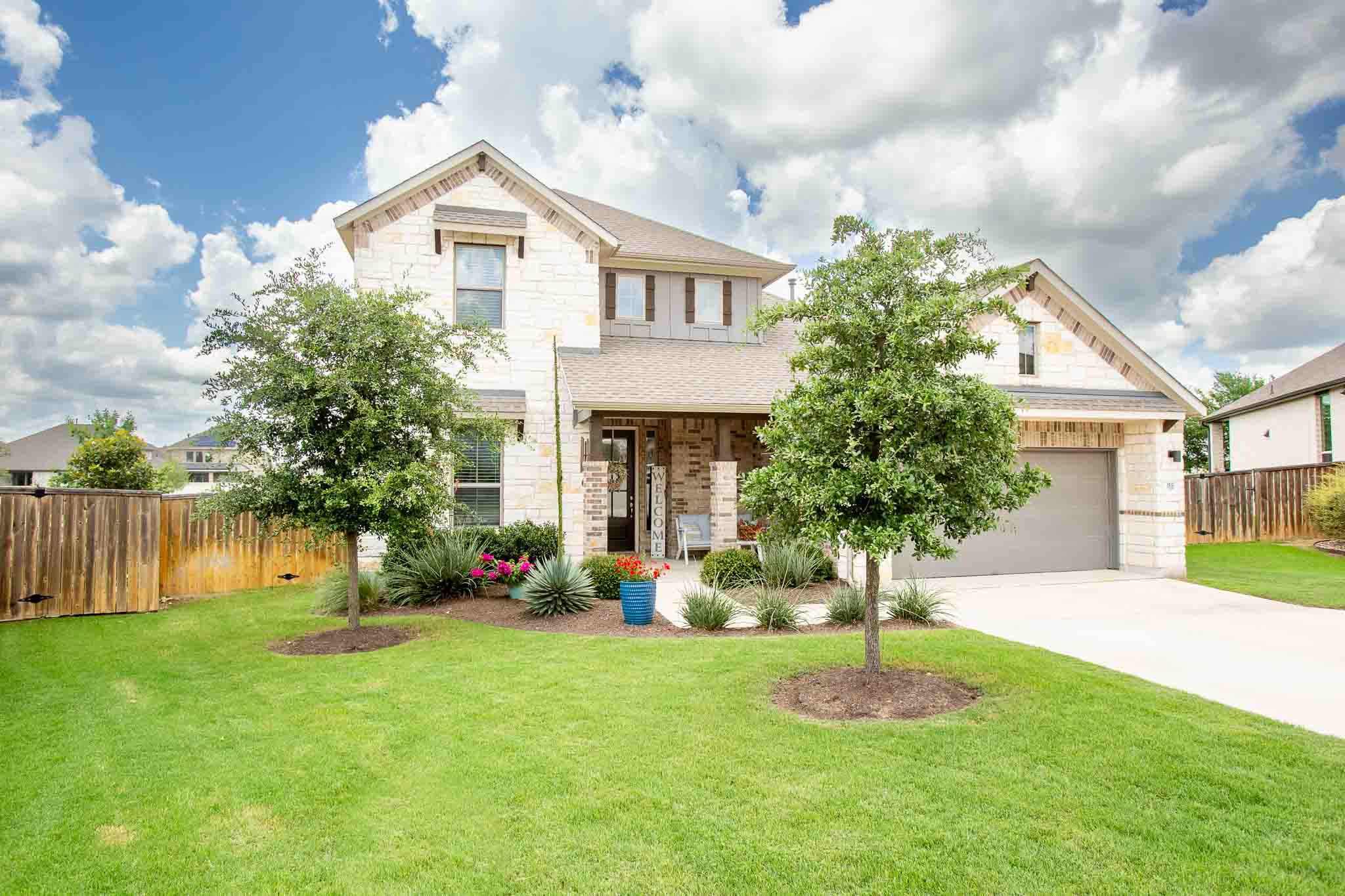 166 West Branch Road Kyle, TX 78640 - Photo 2 of 39 Well-maintained curb appeal with a verdant lawn and mature trees invites you home.
