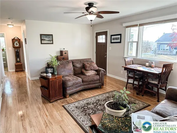 a living room with couches and a flat screen tv with wooden floor