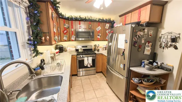 a kitchen with stainless steel appliances a sink a stove and a wooden cabinets