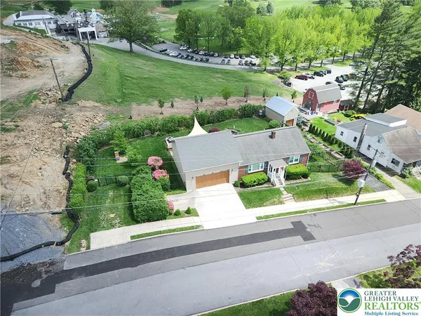 an aerial view of a house with a garden and street view
