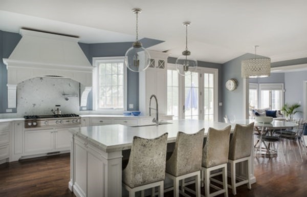 a large kitchen with granite countertop a stove a sink a dining table and chairs